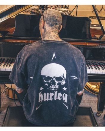 Travis Barker tocando el piano con la camiseta de manga corta Hurley Skull Island Negra