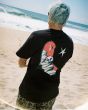 Hombre en la playa con Camiseta Volcom FA Seth Conboy Negra estampado artístico espalda