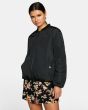 Mujer con chaqueta reversible bomber RVCA Take OFF reverso en negro