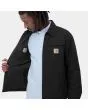 Hombre con cazadora reversible Carhartt WIP Madera Jacket negra y blanca interior