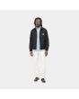 Hombre con cazadora reversible Carhartt WIP Madera Jacket negra y blanca reverso frontal