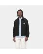 Hombre con cazadora reversible Carhartt WIP Madera Jacket negra y blanca
