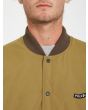 Hombre con chaqueta acolchada reversible Volcom Lookster anverso mostaza cierre botones
