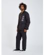 Hombre con chaqueta acolchada reversible Volcom Lookster anverso negra posando lateral