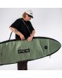 Hombre con Funda surf longboard FCS Day-X 10’0 Alpine colgada al hombro