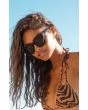 Mujer en la playa con gafas de sol polarizadas I-SEA Harper Negras con lentes ahumadas detalle patilla