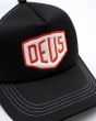 Detalle del parche frontal bordado DEUS de la Gorra Shield Luxx Trucker Negra