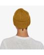 Mujer con gorro Patagonia Brodeo Beanie mostaza unisex posterior