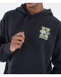 Hombre con Sudadera oversize de capucha Hurley Encore Negra serigrafía pecho