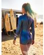 Mujer en la playa con traje de surf corto con manga larga Hurley Air 2/2mm Mid Shorty Azul Brillante cremallera espalda