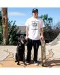 Hombre con perro y monopatín con la Camiseta Independent x Motörhead Warpig blanca