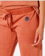Mujer con pantalón de Chándal Rip Curl Surfers Original Naranja detalle logo