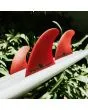Quillas para tabla de surf FCS II Accelerator Neo Glass Eco Tri Fins rojas Large Thruster Set Up lifestyle