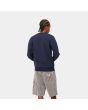 Hombre con sudadera Carhartt WIP Script Embroidery Sweat azul con logo blanco posterior