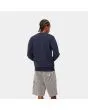 Hombre con sudadera Carhartt WIP Script Embroidery Sweat azul con logo blanco posterior