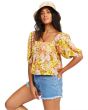 Mujer con Top crop Billabong Beach Daze color mostaza con estampado floral 