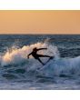 Surfer con neopreno O’Neill Hyperfreak 3/2+ mm negro realizando maniobra en ola al atardecer