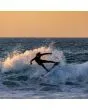 Surfer con neopreno O’Neill Hyperfreak 3/2+ mm negro realizando maniobra en ola al atardecer