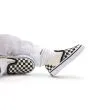 Bebé con Zapatillas Vans Slip-On blancas y negras con estampado Checkerboard detalle