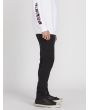 Hombre con pantalón vaquero Volcom 2X4 Denim en color negro lateral