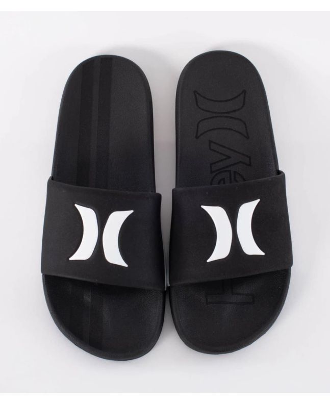 Chanclas Hurley Magu Slide negras y blancas para hombre con logotipo Hurley blanco sobre pala negra