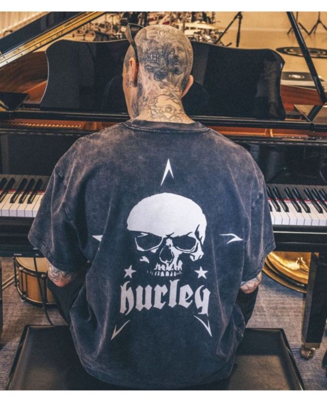 Travis Barker tocando el piano con la camiseta de manga corta Hurley Skull Island Negra