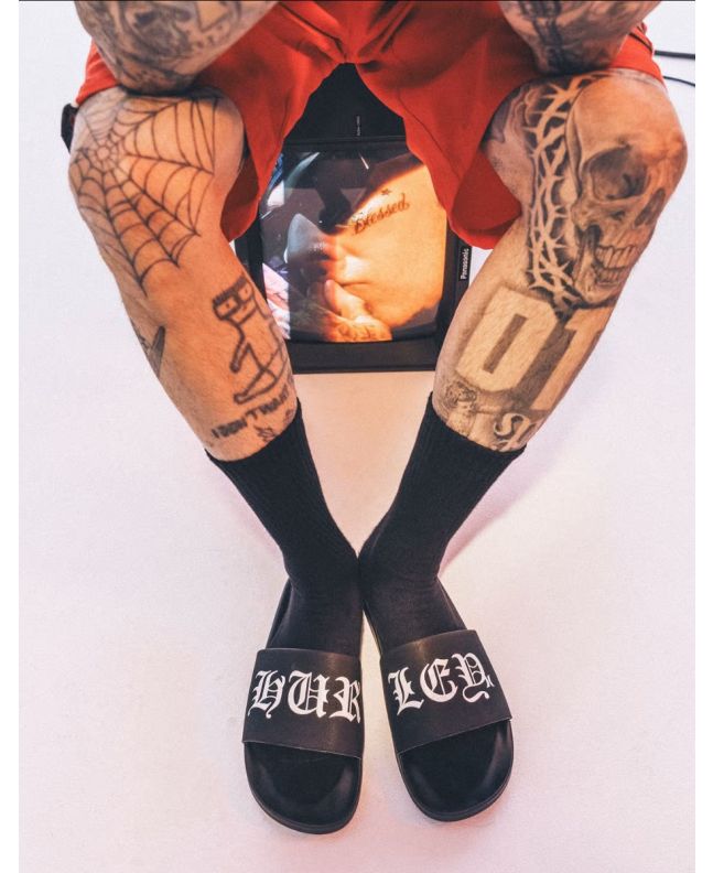 Travis Barker con Chanclas Hurley Slide Negras