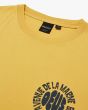 Camiseta surfera de manga corta Deus Ex Machina Biarritz Surf amarilla para hombre etiqueta