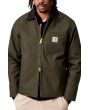 Hombre con chaqueta de invierno Carhartt WIP Detroit Jacket Verde Oliva y Negra cremallera