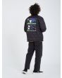 Hombre con chaqueta acolchada reversible Volcom Lookster anverso negra posando posterior
