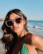 Mujer en la playa con Gafas de sol I-SEA Ivy Rosas con lentes marrones polarizadas