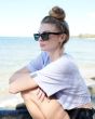Mujer sentada junto al mar con Gafas de sol polarizadas I-SEA Kiki color Black/Smoke lateral