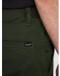 Hombre con pantalón chino Volcom Frickin Modern Stretch verde etiqueta