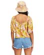 Mujer con Top crop Billabong Beach Daze color mostaza con estampado floral posterior