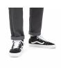 Zapatillas Vans de caña media Mid Skool negras y banda lateral blanca Unisex puestas